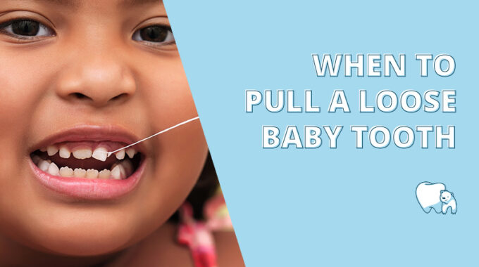 child pulling a loose baby tooth