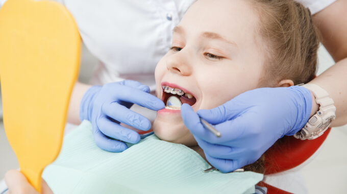 Girl at reception with dentist, conduct an examination of braces and state of enamel from caries.